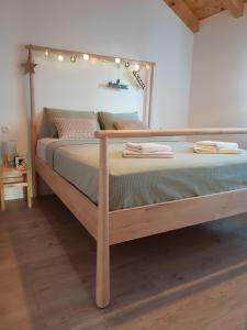 ein Bett mit einem hölzernen Rahmen mit Lampen in der Unterkunft Mila Holiday Home in Vodice
