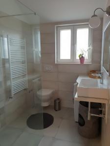 ein weißes Bad mit einem WC und einem Waschbecken in der Unterkunft Mila Holiday Home in Vodice