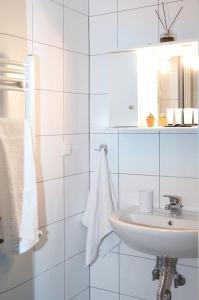 Baño blanco con lavabo y espejo en Stylish Apartment Thessaloniki, en Tesalónica