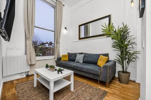 a living room with a couch and a table at Deluxe flat on Kentish Town in London