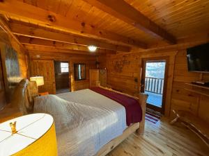 a bedroom with a bed in a log cabin at Smoky Paws - Exceptional Cabin, Stunning Mountain Views, Hot Tub, Tranquil, Gigabit Internet, Free L2 EV in Pigeon Forge