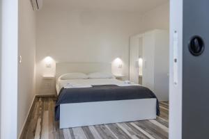 a white bedroom with a bed and two lamps at Essentia Rooms & Relax in Vasto
