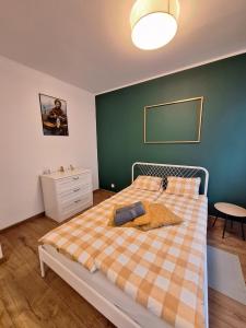 een slaapkamer met een bed met een geruite deken bij Apartament Golda in Toruń