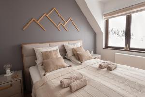 una camera da letto con un letto grande con asciugamani sopra di Glečer Kop, Apartment A14, FREE Parking Garage a Kopaonik