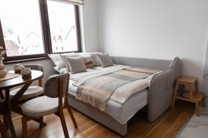 uma cama num quarto com uma mesa e uma janela em Glečer Kop, apartment A14 em Kopaonik