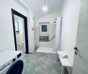 uma casa de banho branca com um chuveiro e um lavatório. em Hd Guesthouse em Chivasso
