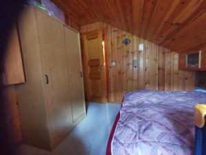 a bedroom with a bed in a wooden cabin at Chalet Dixence in Hérémence