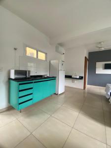 cocina con encimera azul y nevera en Recanto Bromélias, en Camburi