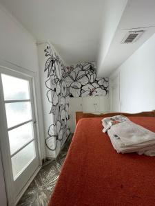 sypialnia z łóżkiem z malowidłem kwiatowym na ścianie w obiekcie Hotel Parque w mieście Necochea