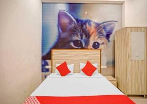 een slaapkamer met een schilderij van een kat aan de muur bij OYO Hotel sweet Elite in Meerut