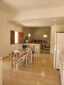 cocina con mesa, sillas y nevera en Casa da Bênção - Praia de Moitas en Amontada