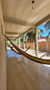 una hamaca en una habitación con palmeras en Casa da Bênção - Praia de Moitas en Amontada