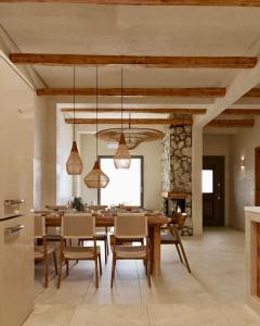 una cucina e una sala da pranzo con tavolo e sedie di Elaia Luxury House a Archangelos