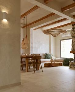 un soggiorno con tavolo in legno e divano di Elaia Luxury House a Archangelos