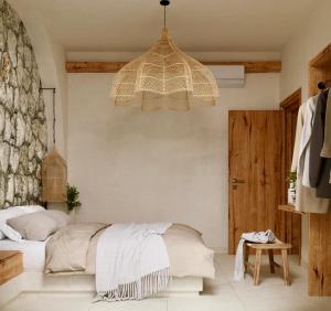a bedroom with a bed and a chandelier at Elaia Luxury House in Archangelos