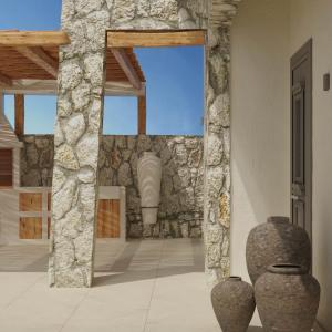 a room with a stone wall and two vases at Elaia Luxury House in Archangelos