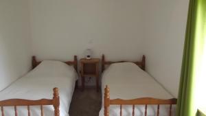 - 2 lits jumeaux dans une chambre aux murs blancs dans l'établissement Gîte des Forges, à Saint Lo