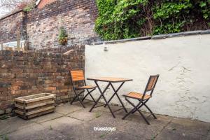 dos sillas y una mesa junto a una pared de ladrillo en NEW Sackville House - Comfy 4 Bedroom House en Stoke on Trent