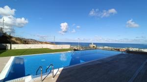 a swimming pool with a view of the ocean at Luxury Las Canteras, pool & gym in Las Palmas de Gran Canaria