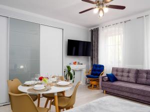 a living room with a table and a purple couch at Apartament Greta in Złoty Stok