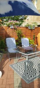 a patio with a glass table and chairs under an umbrella at Apartament Greta in Złoty Stok