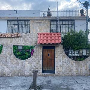 un edificio de piedra con puerta y techo rojo en Calu L' Petit Hostel en Quito