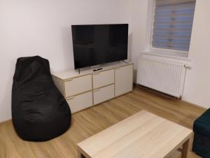 a living room with a black bean bag chair and a television at Apartament Tereska in Duszniki Zdrój