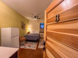 a kitchen with a refrigerator and a bed in a room at Goldfinch Suites in Elkader