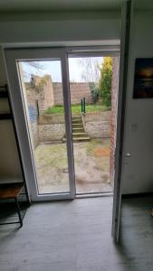 een open deur met uitzicht op een tuin bij Studio Jasmin avec jardin, rénové in Saint-Quentin