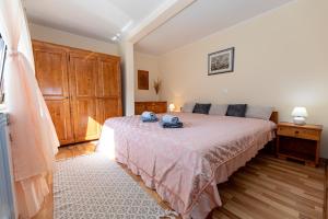 um quarto com uma cama com uma colcha rosa em Apartmani Rumora Gorski kotar em Tuk Vojni