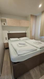 une chambre avec deux lits avec des draps blancs dans l'établissement Mobilna kućica Tara, uvala Slanica, Murter, à Murter