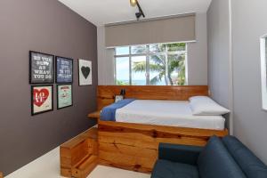 a bedroom with a bed and a blue couch at Studio Oceanview in Rio de Janeiro