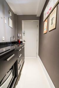 a kitchen with a white door and a sink at Studio Oceanview in Rio de Janeiro