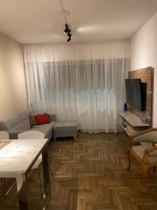 a living room with a couch and a tv at HERMOSO DEPARTAMENTO CENTRICO (1) in Cordoba