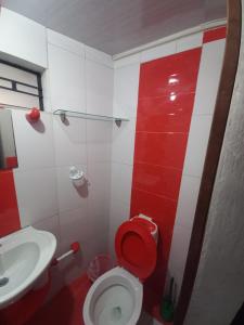 a red and white bathroom with a toilet and a sink at Cabaña Vacacional Donde Ibañez in Fusagasuga