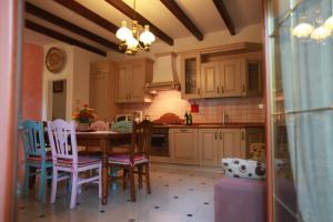a kitchen with a wooden table and chairs and a kitchen with at Villa orchidea in Rosolina Mare