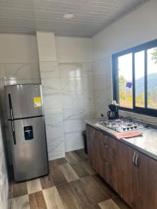 eine Küche mit einem Kühlschrank aus Edelstahl und einer Theke in der Unterkunft Mirador Villa Natalia in San Gil