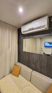 ein Wohnzimmer mit Sofa und Klimaanlage in der Unterkunft Mobilna kućica Tara, Kamp Rehut, uvala Slanica, Murter in Murter