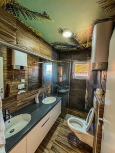 a bathroom with two sinks and a toilet in it at Kod Šmece apartmani - Valjevo in Valjevo