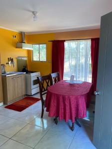 uma cozinha com uma mesa com uma toalha de mesa roxa em Cabaña em Chillán
