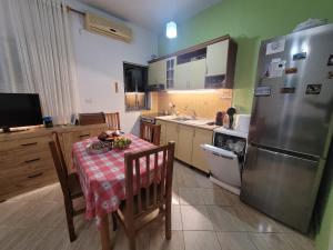 a kitchen with a table and a stainless steel refrigerator at Garden house in Kashari