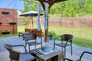 a patio with chairs and a table with an umbrella at Our Corner Cottage in Aiken