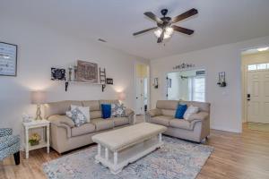 a living room with two couches and a ceiling fan at Our Corner Cottage in Aiken