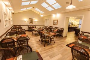a restaurant with tables and chairs in a room at Planalto Select Hotel Ponta Grossa in Ponta Grossa