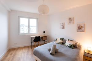 um quarto com uma cama, uma secretária e uma janela em T3 avec Balcon St Patern / Gare em Vannes