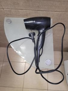 a black hair dryer sitting on top of a white box at Garden house in Kashari