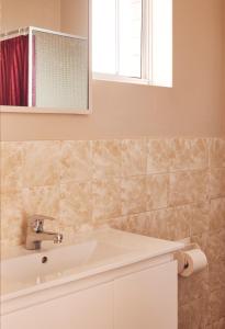 La salle de bains est pourvue d'un lavabo et d'un miroir. dans l'établissement Coastal Comfort Motel, à Narooma
