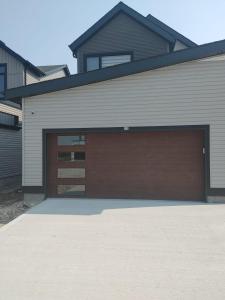 a garage with a brown garage door on a house at Stylish Basement Suite with Modern Comforts in Winnipeg