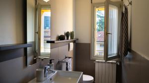 ein Badezimmer mit Waschbecken, Toilette und Spiegel in der Unterkunft Casa Manara - Sunset view in Bergamo + 20 Fotos