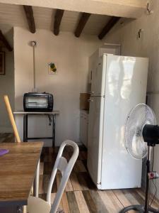 a kitchen with a white refrigerator and a microwave at Cab, SE ,1 in Villa Los Aromos